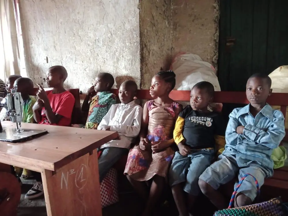 Children waiting at tailoring workshop