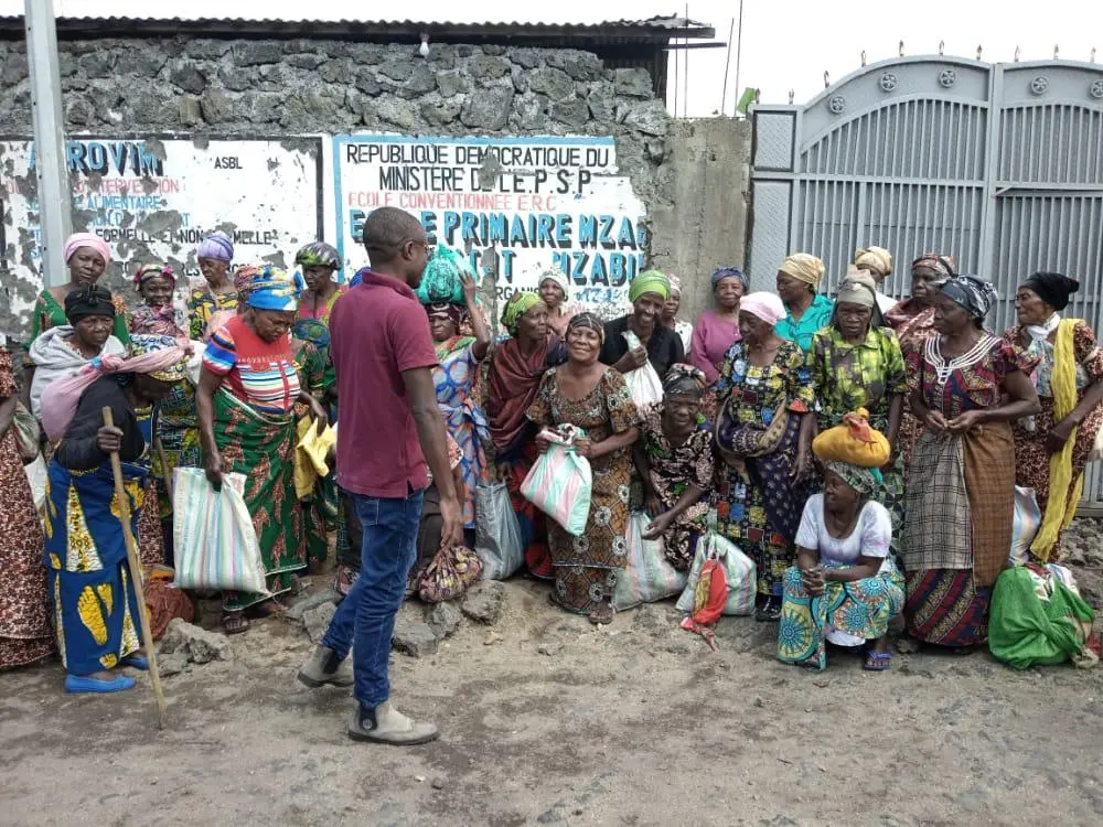 Widows with food bags at the school gate