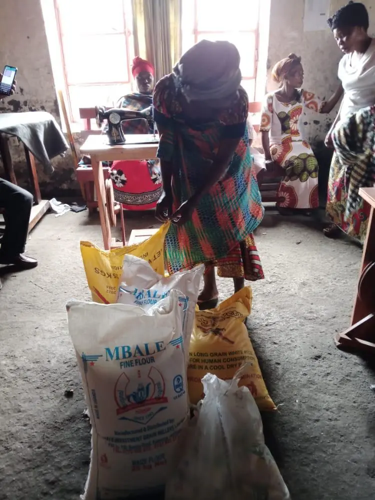Woman receiving flour and rice in tailoring workshop